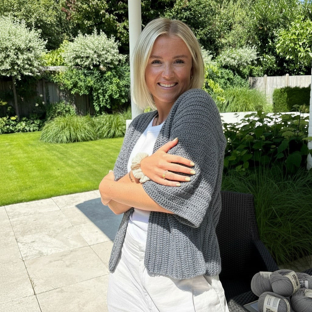 Model trägt einen grauen 🧶 BellaLana Bambus-Cardigan mit Kimono-Ärmeln und Stäbchenmuster im Garten.