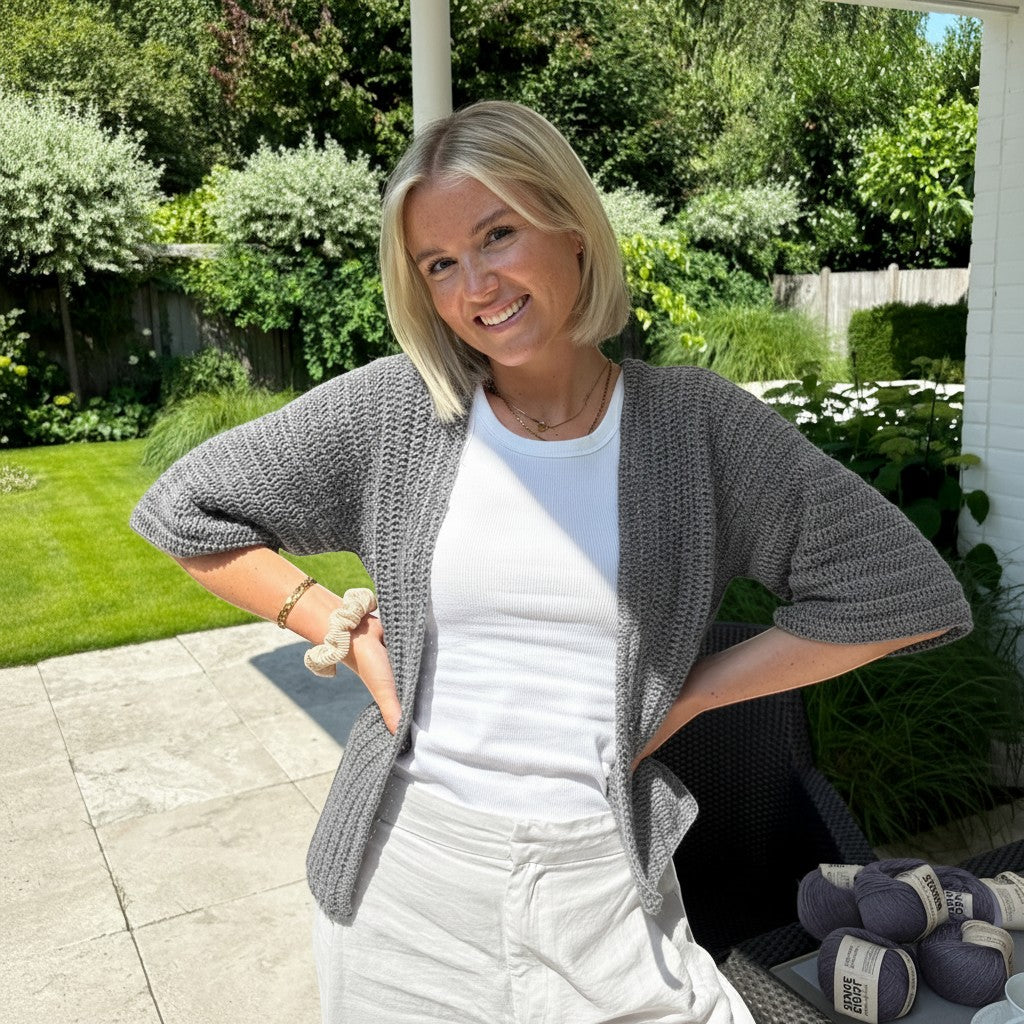 BellaLana Häkel-Set für einen grauen Cardigan mit Kimono-Ärmeln aus Bambus-Garn, getragen von einer Frau im Garten.