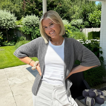 BellaLana Häkel-Set für einen grauen Cardigan mit Kimono-Ärmeln aus Bambus-Garn, getragen von einer Frau im Garten.